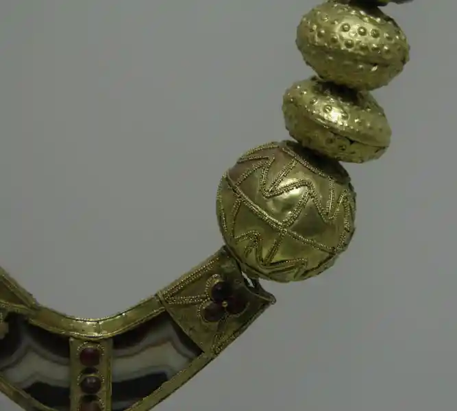 Gold necklace with beads with cross.